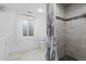 Bathroom features a tiled shower, shower curtain, a toilet, and a window with white curtains at 2640 Overlook Dr, Broomfield, CO 80020