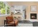Comfortable living room view, showcasing fireplace, kitchen, and ample natural light at 2640 Overlook Dr, Broomfield, CO 80020