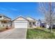 Inviting single-story home showcasing a two-car garage, manicured lawn and stone accents that enhance curb appeal at 12868 Capital Creek St, Parker, CO 80134