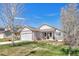 Charming single-story home featuring a well-kept lawn, complemented by stone accents and a blossoming tree at 12868 Capital Creek St, Parker, CO 80134