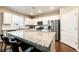 Bright kitchen featuring white cabinets, stainless steel appliances, and a large granite island with bar seating at 27089 E Cedar Ave, Aurora, CO 80018