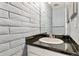 Stylish half bathroom featuring a modern vanity with a black countertop and sleek fixtures at 1060 S Parker Rd # 25, Denver, CO 80231