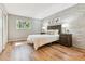 Cozy bedroom with a brick accent wall, natural light, and hardwood floors at 1060 S Parker Rd # 25, Denver, CO 80231
