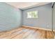 Bright, empty bedroom with a view from a large window and a brick accent wall at 1060 S Parker Rd # 25, Denver, CO 80231