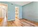 Light-filled bedroom featuring a rustic accent wall and wood-look floors, leading to an ensuite bathroom at 1060 S Parker Rd # 25, Denver, CO 80231