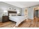 Bedroom with a brick accent wall, wood floors, and view to the bathroom at 1060 S Parker Rd # 25, Denver, CO 80231