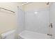 Clean bathroom featuring a white marble style shower-tub combo and a white toilet at 10185 W 25Th Ave # 33, Lakewood, CO 80215