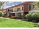 A condo building featuring a nice green lawn, balconies with black railings, and beautiful landscaping at 10185 W 25Th Ave # 33, Lakewood, CO 80215