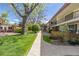 A condo building featuring black railings, a well-manicured lawn, and mature shade trees at 10185 W 25Th Ave # 33, Lakewood, CO 80215