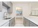 Modern kitchen with gray cabinets and bright counter tops, offers a view to the combined living and dining room at 10185 W 25Th Ave # 33, Lakewood, CO 80215