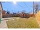 A fenced backyard with a brick structure, grassy lawn, concrete patio and stepping stones at 1467 Clermont St, Denver, CO 80220