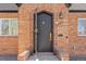 Close-up of the home's beautiful ornate front door, brick facade, and outdoor lighting fixture at 1467 Clermont St, Denver, CO 80220