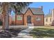 Charming brick home with an ornate front door, well-manicured lawn, and a walkway leading to the entrance at 1467 Clermont St, Denver, CO 80220