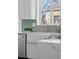 Close-up of modern kitchen sink and countertop, featuring stainless steel appliances and floating wood shelves at 1467 Clermont St, Denver, CO 80220