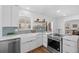 Modern kitchen features stainless steel appliances, bright windows, and an island with a sink and counter seating at 1467 Clermont St, Denver, CO 80220