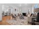 Bright living room featuring hardwood floors, a decorative rug, comfortable seating, and arched doorways at 1467 Clermont St, Denver, CO 80220