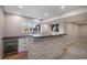 Basement bar features a stone accent wall and a beverage fridge enhancing the entertainment possibilities of the living space at 4431 W Jamison Pl, Littleton, CO 80128