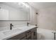 Modern bathroom featuring a double vanity, soaking tub, and updated fixtures showcasing contemporary style and functionality at 4431 W Jamison Pl, Littleton, CO 80128