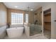 This bathroom features a standalone tub, walk-in shower, and a window for natural light at 4431 W Jamison Pl, Littleton, CO 80128