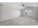 Large bedroom with neutral carpet, a ceiling fan, and a window with shutters at 4431 W Jamison Pl, Littleton, CO 80128