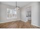 Dining room features a modern chandelier and shuttered windows, with wood-look floors throughout at 4431 W Jamison Pl, Littleton, CO 80128