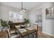 Dining room features a modern chandelier, shuttered windows, and decor, adjacent to the kitchen at 4431 W Jamison Pl, Littleton, CO 80128
