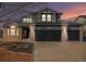 Charming two-story home featuring a brick and gray siding facade, attached two-car garage, and manicured landscaping at 4431 W Jamison Pl, Littleton, CO 80128