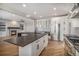 Gourmet kitchen with stainless steel appliances and stone countertops looks into adjacent living room at 4431 W Jamison Pl, Littleton, CO 80128