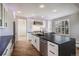 Stunning kitchen with custom white cabinetry, stainless steel appliances, and sleek black countertop island at 4431 W Jamison Pl, Littleton, CO 80128