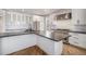 A modern white kitchen features stainless steel appliances, black countertops, and wood flooring at 4431 W Jamison Pl, Littleton, CO 80128