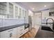 Bright kitchen features white cabinets, stainless steel appliances, black countertops, and modern fixtures at 4431 W Jamison Pl, Littleton, CO 80128