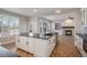 An open-concept white kitchen features wood flooring and views into a living room with a fireplace at 4431 W Jamison Pl, Littleton, CO 80128