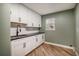 Laundry room with white cabinets, black countertops, modern faucet, and ample storage at 4431 W Jamison Pl, Littleton, CO 80128