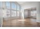 Spacious living room featuring soaring ceilings, many large windows with shutters, and wood-look floors at 4431 W Jamison Pl, Littleton, CO 80128