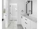 This bathroom has an elegant single sink, a white vanity, and a decorative black framed mirror at 1346 N Knox Ct, Denver, CO 80204