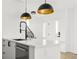 This kitchen features a quartz countertop island with a black faucet, and stainless steel appliances under modern lighting at 1346 N Knox Ct, Denver, CO 80204