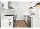 Modern white kitchen with stainless steel appliances, hardwood floors, and matte black hardware at 1346 N Knox Ct, Denver, CO 80204