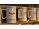 Charming Seedstock Brewery mugs lined up, showcasing a gold rim with branded logo, ready for enjoying craft beers at 1346 N Knox Ct, Denver, CO 80204