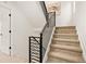 Carpeted staircase with modern black railings and bright white walls at 1346 N Knox Ct, Denver, CO 80204