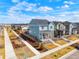 An elevated street view of a neighborhood showcasing a blue two-story home with a red front door at 21209 E 62Nd Ave, Aurora, CO 80019