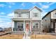 Charming two-story home featuring stone accents, covered porch, and inviting orange front door at 21209 E 62Nd Ave, Aurora, CO 80019
