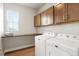 Functional laundry room features stainless steel appliances, wood floors, and ample cabinet space at 21209 E 62Nd Ave, Aurora, CO 80019