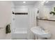 Clean bathroom featuring subway tile, shower-tub combination, and a pedestal sink at 1644 S Garfield St, Denver, CO 80210