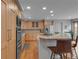 Well-lit kitchen featuring wood cabinetry, stainless steel appliances, and a granite island with bar stools at 1644 S Garfield St, Denver, CO 80210