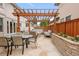 Outdoor patio with pergola, string lights, fire pit, and dining table in backyard at 1644 S Garfield St, Denver, CO 80210