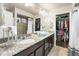 Bathroom featuring granite counters, dual sinks, and a walk-in closet for ample storage space at 18651 E 53Rd Ave, Denver, CO 80249
