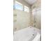 Bright bathroom with white tub, shower fixtures, and tiled walls with decorative accents at 18651 E 53Rd Ave, Denver, CO 80249