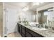 Well-appointed bathroom with a double vanity, granite countertops, and a glass-enclosed shower at 18651 E 53Rd Ave, Denver, CO 80249