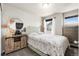Bright bedroom with light walls, a window, a dresser, and a wooden nightstand at 18651 E 53Rd Ave, Denver, CO 80249