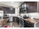Contemporary kitchen with stainless steel appliances, dark cabinetry, and granite countertops at 18651 E 53Rd Ave, Denver, CO 80249